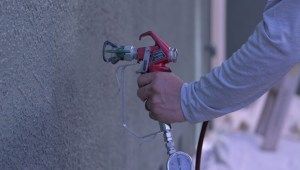 man using spray gun with tip on it